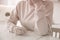 Woman holding wedding ring at table indoors. Cheating and breakup