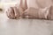 Woman holding wedding ring at table indoors, closeup. Cheating and breakup