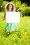 Woman holding white blank poster in summer park