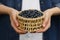 Woman holding wicker bowl of bilberries, closeup