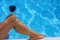 Woman holding wine on her knee at the poolside