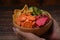 Woman holding wooden bowl with mixed vegetable chip dehydrated snack.