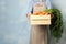 Woman holding wooden crate with fresh ripe carrots against color background