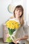 Woman holding yellow narcissus. Beautiful bouquet of spring daffodils in her hands as a gift.