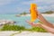 Woman holding yellow sunscreen bottle in hands