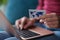 Woman holds bank card in hands and enters data into laptop closeup