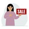 A woman holds a banner with the text sale. Points a finger at the text. The concept of a discount, a special offer in a