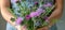 a woman holds a bouquet of thistles