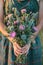 a woman holds a bouquet of thistles