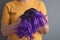 woman holds a bright purple wig in her hands. Womens beauty concept