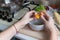 A woman holds a broken egg over a bowl in her kitchen. Food blogger.