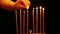 A woman holds a candle in her hand and lights candles in a Hanukkah candlestick. camera movement from right to left