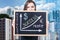 Woman holds chalkboard with financial graph