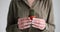 Woman holds decorative cactus with sharp thorns in hands