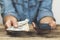 Woman holds dollars and phone in her hands. Online money transfer