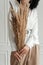 woman holds ears of corn in her hands. Artificial flowers