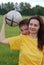 Woman holds football, boy peeps out