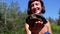 Woman Holds Funny Turtle in Arm and Smiles on River with Green Vegetation