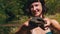 Woman Holds Funny Turtle in Arm and Smiles on River with Green Vegetation