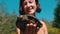 Woman Holds Funny Turtle in Arm and Smiles on River with Green Vegetation