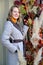 Woman holds with hand a branch with physalis fruits on the background of a building