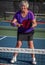 Woman holds her pickleball paddle ready for a volley