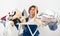 A woman holds an iron in her hands and sits at the ironing table. dirty laundry before ironing after washing