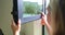 Woman holds microfiber dust cleaning cloth on crossbar of glass window