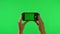 Woman holds mobile phone with workspace mock up screen on green background. Female hand clicking button to take photo