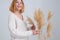 The woman holds the pampas grass in hands. Reed stem, dried pampas grass, decorative feather composition for home, beach theme,