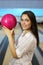 Woman holds pink ball in bowling club