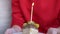 A Woman Holds a Plate with a Piece of Birthday Cake and One Lighted Candle. Zoom