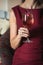 Woman holds relaxing alcoholic pink coctail with a rose on top