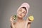 Woman holds a ripe mango in her hand bare shoulders with a towel on her head