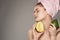 Woman holds a ripe mango in her hand bare shoulders with a towel on her head