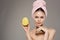 Woman holds a ripe mango in her hand bare shoulders with a towel on her head