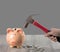 A woman holds a rusty hammer to smash a piggy bank