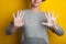 Woman holds and shows soaped hands. Palms and fingers in soapy foam on a yellow background. Hand disinfection in the fight against