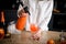 Woman holds siphon in her hand and pours liquid into glass