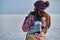 A woman holds skates on her shoulder after skiing on a frozen lake