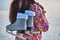 A woman holds skates on her shoulder after skiing on a frozen lake