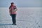 A woman holds skates on her shoulder after skiing on a frozen lake