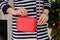 Woman holds a small stylish bag clutch of bright red color wit