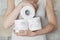 Woman holds some rolls of toilet paper in her arms in the bathroom