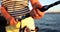 Woman holds spinning rod in hands and fishing in sea