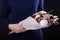 Woman holds a sweet eatable bouquet wrapped in paper on black background