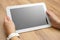 Woman holds tablet computer on desk with empty screen