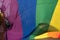 Woman holds up part of the giant rainbow flag at the London Pride Parade 2018. Woman`s face is hidden by the flag.