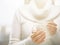 Woman holds a winter cup close up. Woman hands with elegant french manicure nails design holding cozy knitted mug.