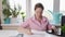 woman at home counting utility bills on a calculator, employee typing on her computer at her designated workstation, professional